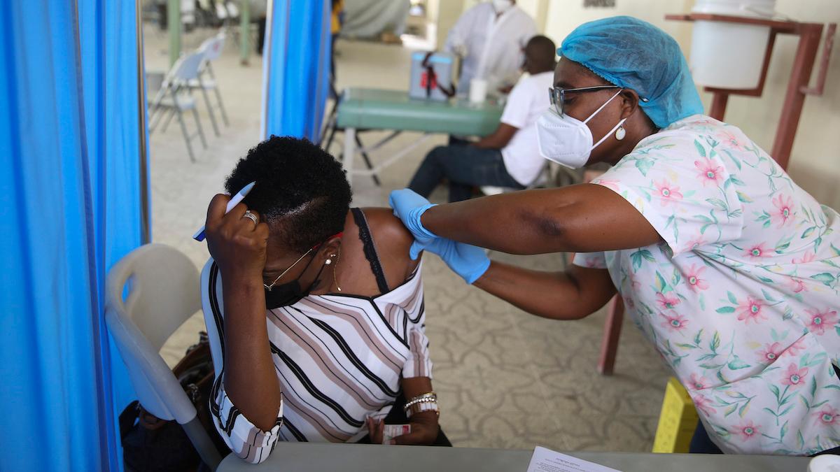 En kvinna i Haiti får covid-19-vaccin som donerades genom Covax-initiativet. Nu menar IFPMA, en branschorganisation som representerar läkemedelsföretag runt om i världen, att Covax inte var tillräckligt finansierat och att global distribution av vaccin måste ske på annat sätt