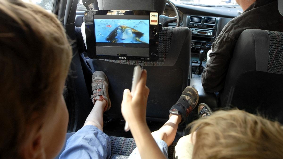 barn i bilbaksäte tittar på film