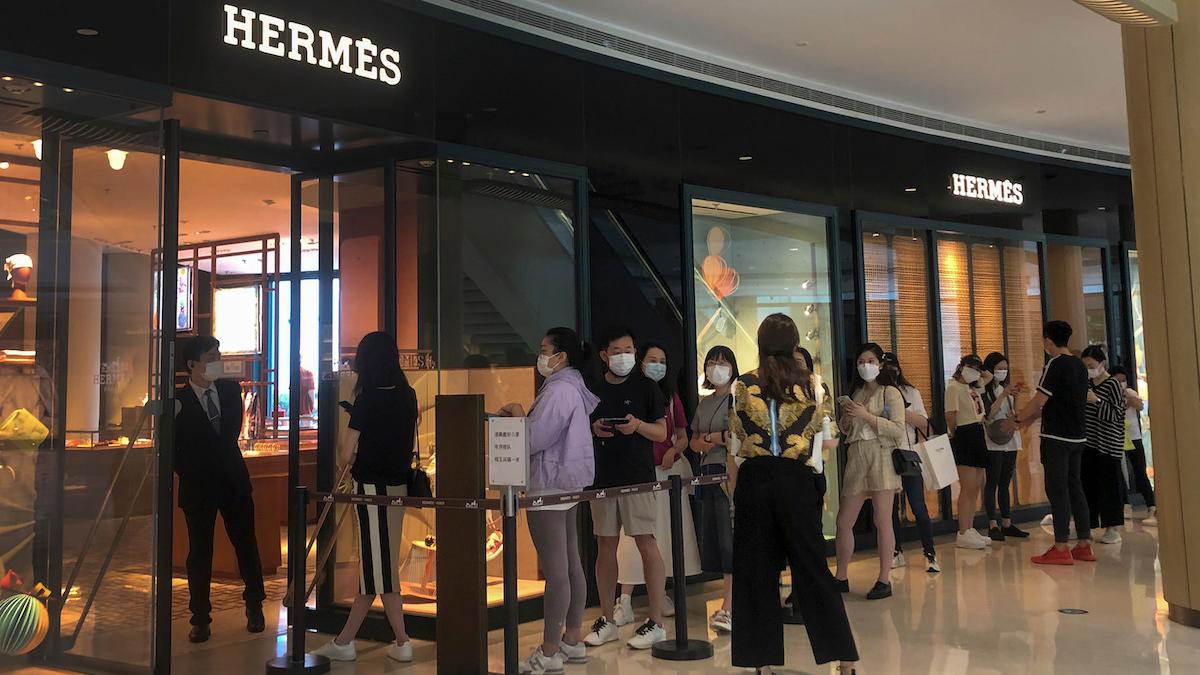 Shoppare i Kina väntar utanför en Hermèsbutik i en återöppnad galleria