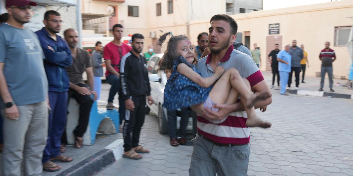 En palestinier springer med sitt barn som skadats i det israeliska bombardemanget av Gaza vid Al-Aqsa-sjukhuset i den 18 oktober 2023, konflikten riskerar att förvärras av desinformation