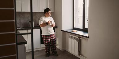 En ensam man tittar ut genom köksfönstret. Över 36 procent av alla hushåll i Sverige är ensamhushåll, men inneber det att vi svenskar är mer ensamma än andra?