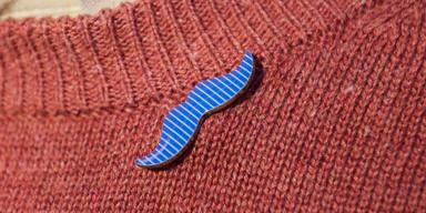 Pin med Mustaschkampens symbol. I Sverige anordnar Prostatacancerförbundet varje år Mustaschkampen för att öka kunskapen om prostatacancer och mäns hälsa, samt samla in pengar till forskning