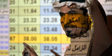 Saudisk trader pekar på siffror vid en presentation.