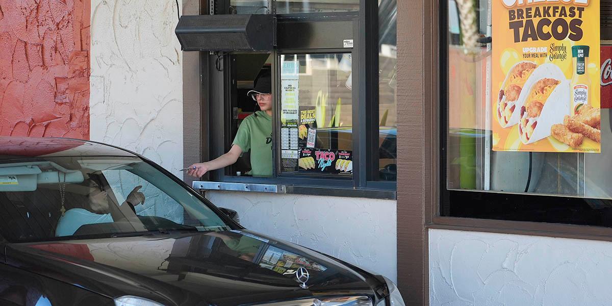En kund som beställer mat i en drive-thru.