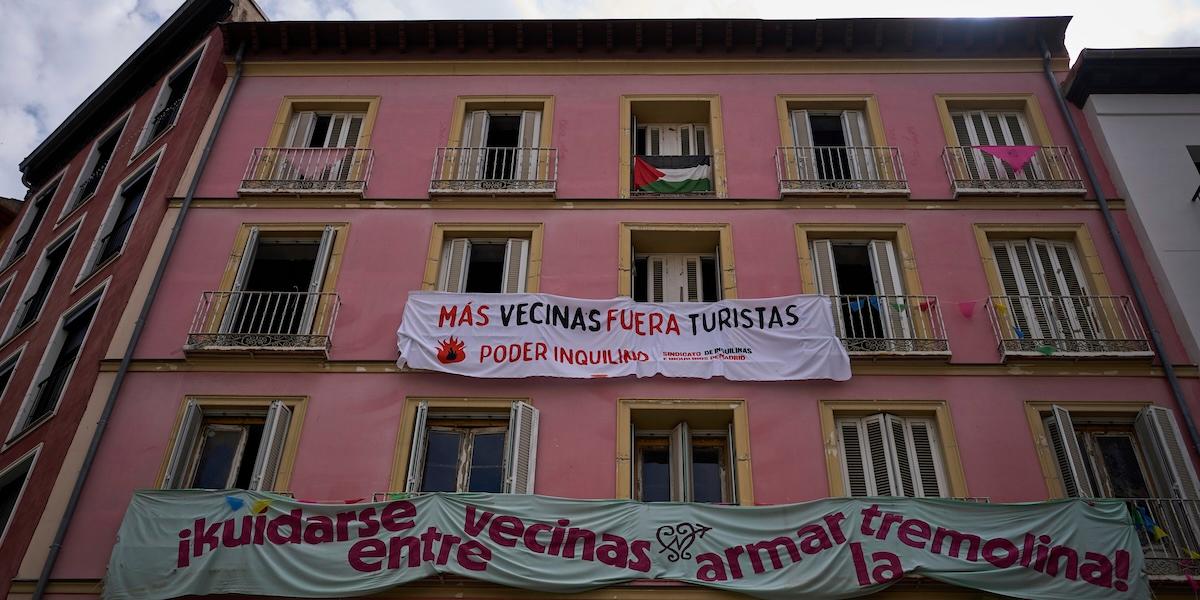 Banderoller mot turistuthyrningar hänger på en byggnadsfasad i centrala Madrid, Spanien. Texterna uppmanar till färre turister och starkare hyresgästinflytande