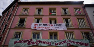 Banderoller mot turistuthyrningar hänger på en byggnadsfasad i centrala Madrid, Spanien. Texterna uppmanar till färre turister och starkare hyresgästinflytande