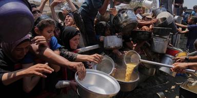 Palestinier försöker få donerad mat vid ett soppkök i Gaza City i norra Gazaremsan på lördagen. En FN-stödd organisation varnar för att ett ”värsta tänkbara scenario av svält” utvecklas i området.