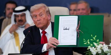 USA:s president Donald Trump visar upp det undertecknade avtalet vid toppmötet om vapenvilan i Sharm el-Sheikh, Egypten, den 13 oktober.