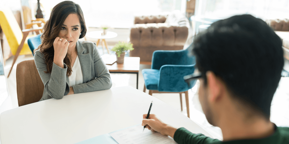 kandidat i jobbintervju ser fundersam när rekryterare ställer öppningsfrågan