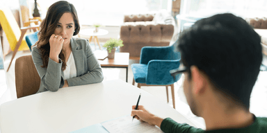 kandidat i jobbintervju ser fundersam när rekryterare ställer öppningsfrågan