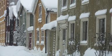 Snötäckta hus i Kalmar under vintern. Bostadsmarknaden visar försiktig uppgång enligt SEB:s Boprisindikator, men räntekylan lurar kvar.