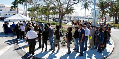 Arbetssökande i kö vid en jobbmässa i Florida – symbol för den bromsande arbetsmarknaden i USA.