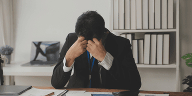 Stressad kontorsanställd på arbetsplats som påverkas av AI-omställning och minskade juniora roller.