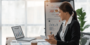 Företagare analyserar ekonomiska rapporter inför årsskiftet, med laptop och grafer på skrivbordet.