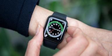 Person justerar sin Apple Watch med svart armband – en vanlig smartwatch som används för att mäta hälsa och sömn.