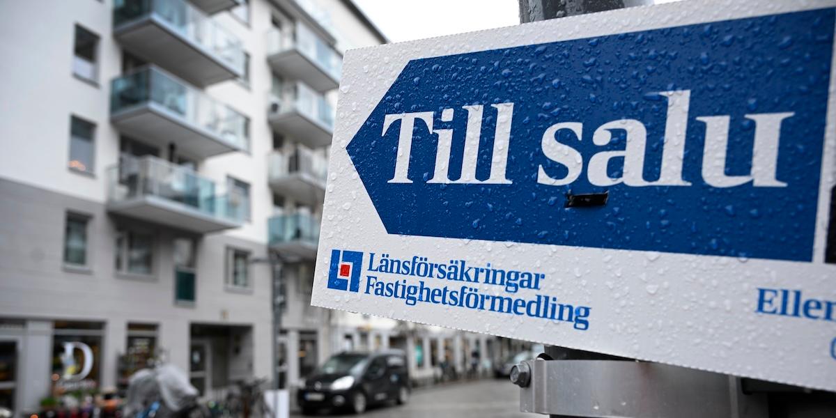 Till salu-skylt utanför moderna bostäder i Sverige, symboliserar rörelse på bostadsmarknaden.