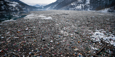 Plastflaskor och annat skräp flyter i sjön Potpecko nära Priboj i sydvästra Serbien. (Foto: Darko Vojinovic/AP/TT)