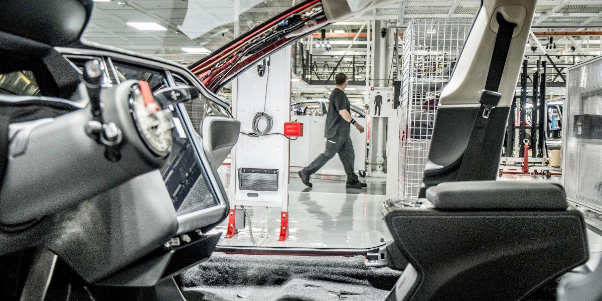 En man skymtar mellan stommen av en obyggd bil.