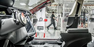 En man skymtar mellan stommen av en obyggd bil.