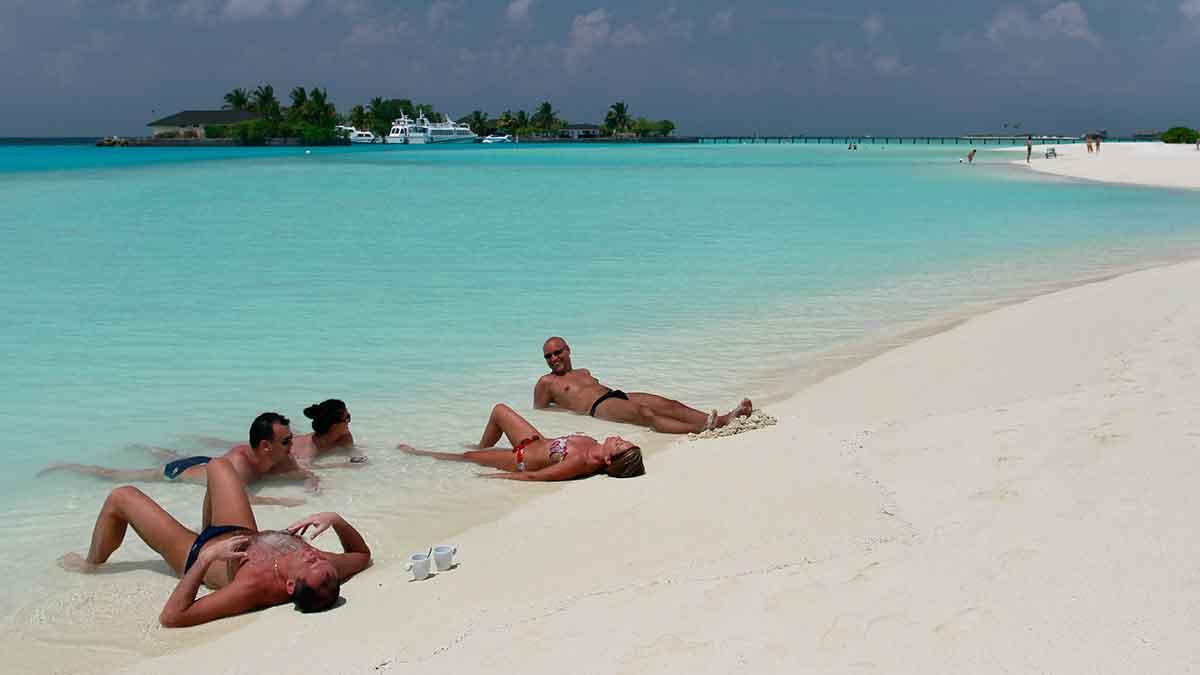 Svenskarna drömmer exotiska resmål. På bilden syns turister på Maldiverna. (Foto: TT)