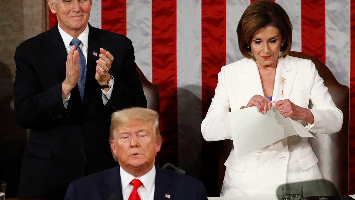 Här river den amerikanska talmannen Nancy Pelosi demonstrativt sönder en kopia på talet till nationen bakom ryggen på president Trump. (Foto: TT)