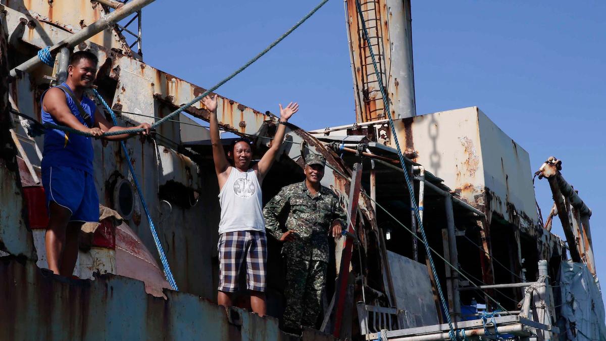 Filippinska marinsoldater vinkar av ett regeringsfartyg som tagit dem till det förfallna filippinska fartyget BRP Sierra Madre för tjänstgöring vid omtvistade Thomas Shoal
