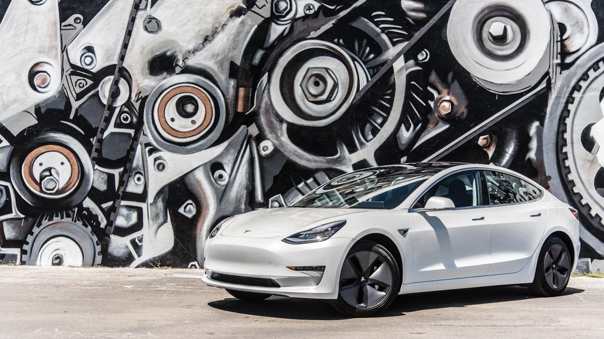 Tesla elbil med motor i bakgrunden.