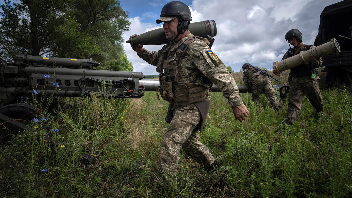 En ukrainsk soldat bär en 155-millimeters artillerigranat i juli 2022. EU väntas i dag nå en överenskommelse om att förse Ukraina med 1 miljon artillerigranater