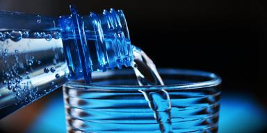 Vatten hälls upp ur en plastflaska: Vatten som säljs i plastflaskor innehåller i genomsnitt 240 000 plastpartiklar av vilka 90 procent är nanoplast
