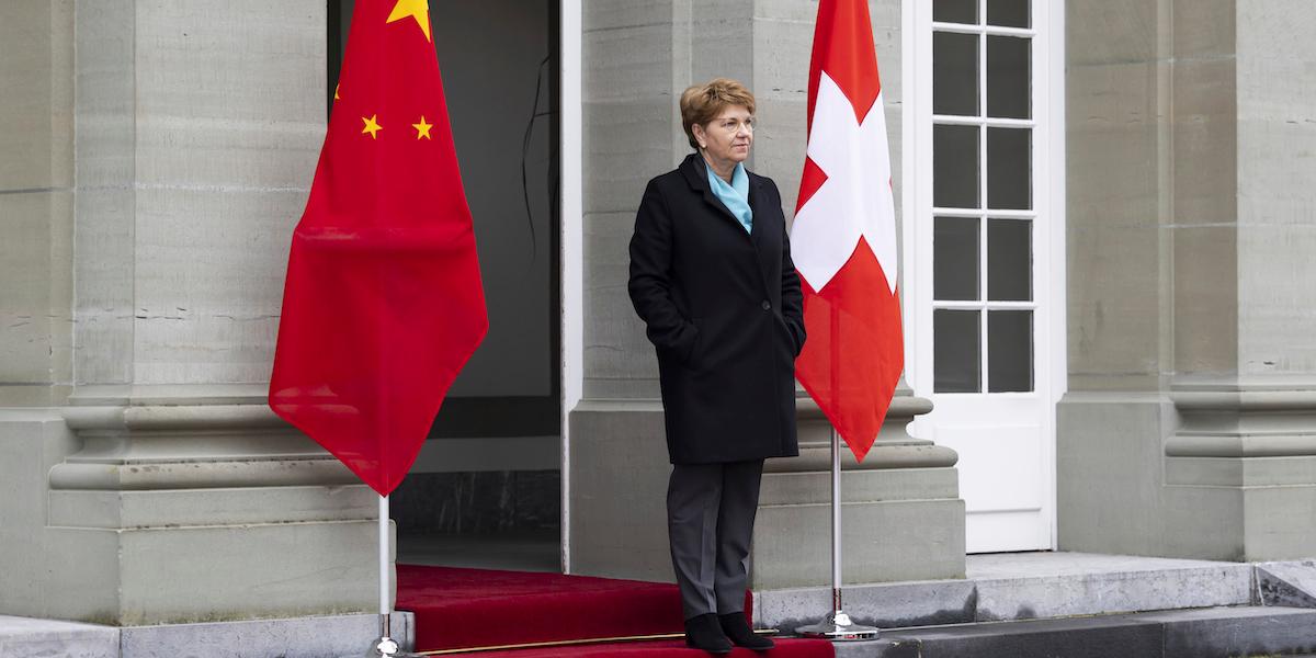 Schweiz förbundspresident Viola Amherd står mellan den kinesiska och den schweiziska flaggan