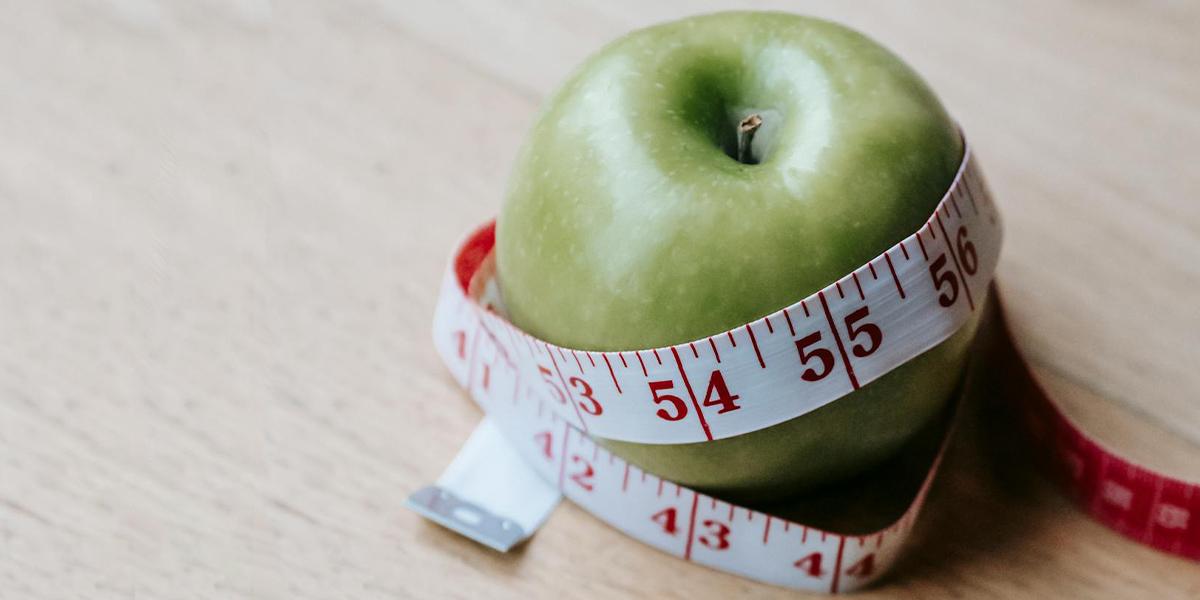 Ett äpple med ett måttband. Är din kropp äppelformad, rund med större midja och smalare höfter? Det har visat sig att vår kroppsform påverkar risken att drabbas av cancer i tjock- och ändtarmen