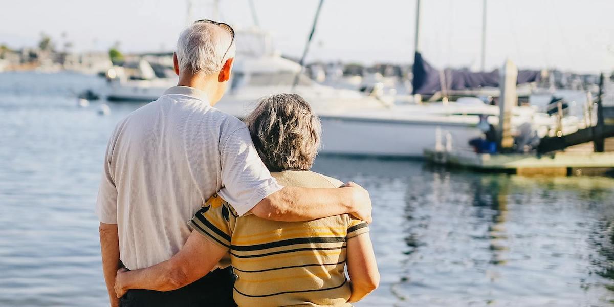 Ett äldre par håller om varandra. Alla tycker inte att det är bäst att vänta med att ta ut sin pension utan tycker att det bästa är att ta ut den så fort det går