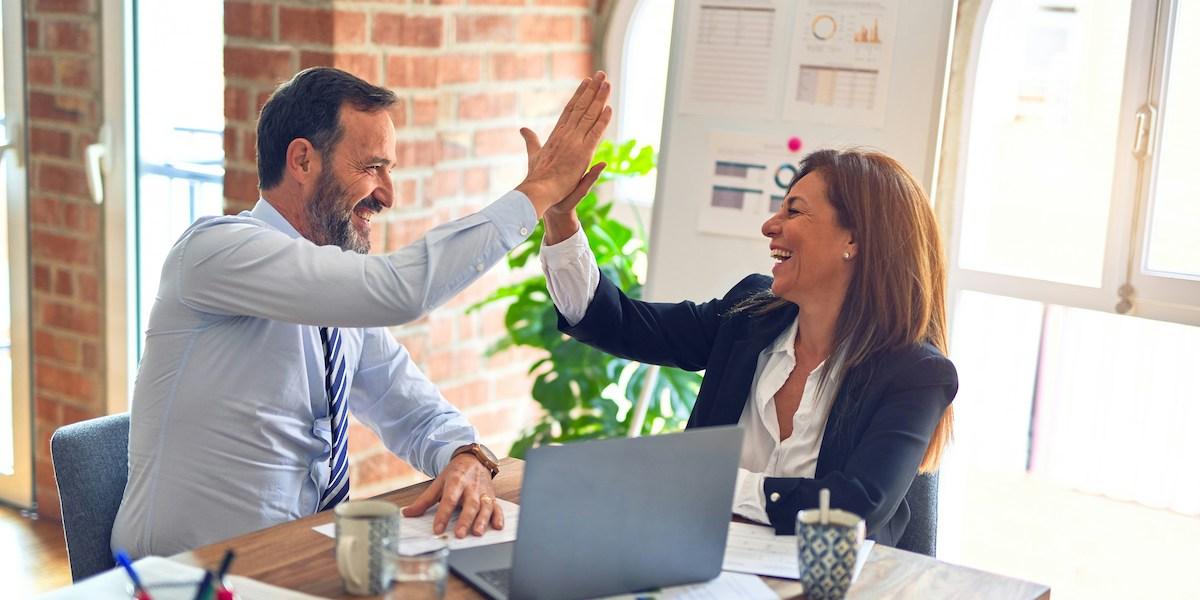 Anställda personer gör high-five. Lär dig landa drömjobbet före alla andra.
