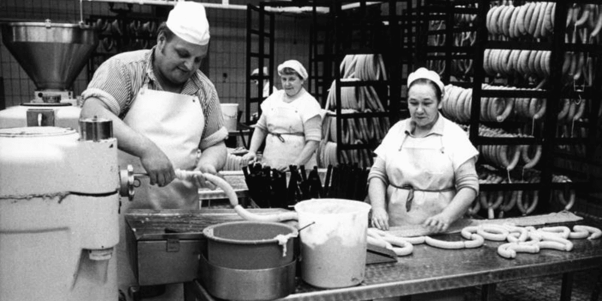 Slaktare som spritsar bock- och currywurst. I bakgrunden hänger korv för rökning. (Foto: Lothar Schaack Creative Commons Attribution-Share Alike 3.0 de)