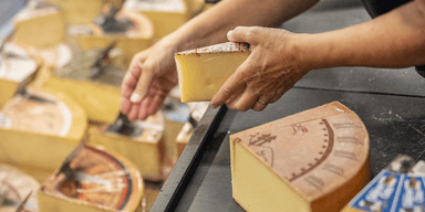 En hand som skär ost