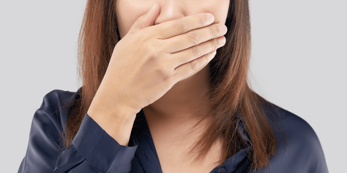 Person som täcker munnen med handen för att illustrera en farlig mening man inte bör säga på en intervju.