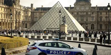 En polisbil står parkerad på Louvrens innergård i Paris den 26 oktober 2025, en vecka efter kuppen. Flera misstänkta har gripits för stölden av kronjuveler från museet.