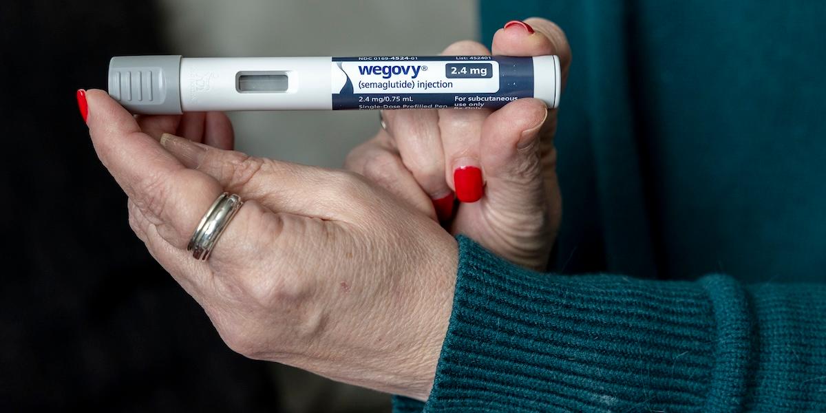 Hand som håller en Wegovy‑injektionspenna med läkemedlet semaglutid.