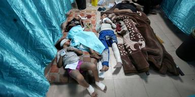 Palestinska barn som skadats av israeliskt bombardemang ligger på Aqsa-sjuhusets golv. Enligt WHO har 26 av 36 sjukhus i Gaza stängts helt